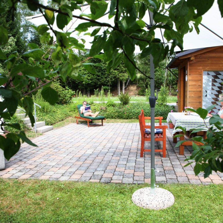 Entspannen auf der Terrasse mit Gartenliege und Sonnenschirm in Zwiesel Großzügige Terrasse der Ferienwohnung Wernerhäusl mit Gartenliege und Sonnenschirm im Grünen