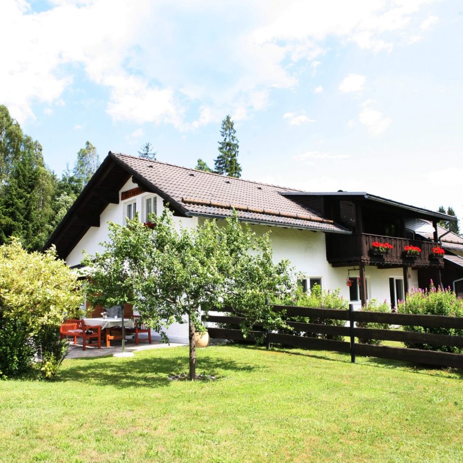 Ferienhaus Wernerhäusl in Zwiesel mit großzügiger Terrasse und Gästen beim gemütlichen Essen im Grünen